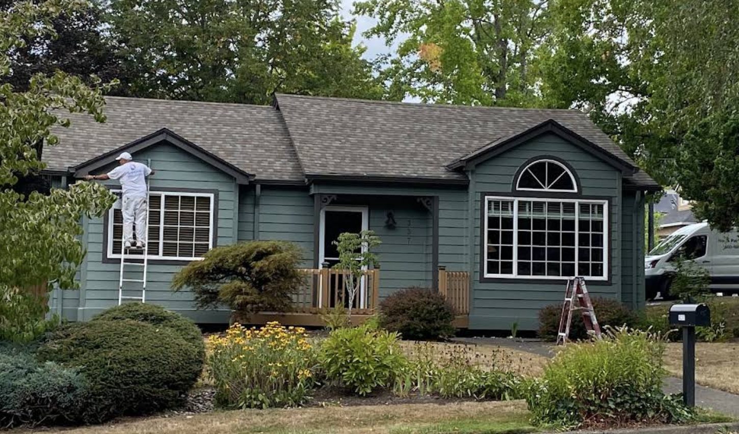 Blue two-story house exterior with white trim painted by Noe's Painting